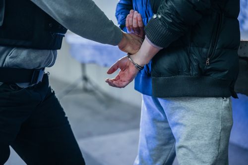 Policeman putting a handcuffs on criminal's hands